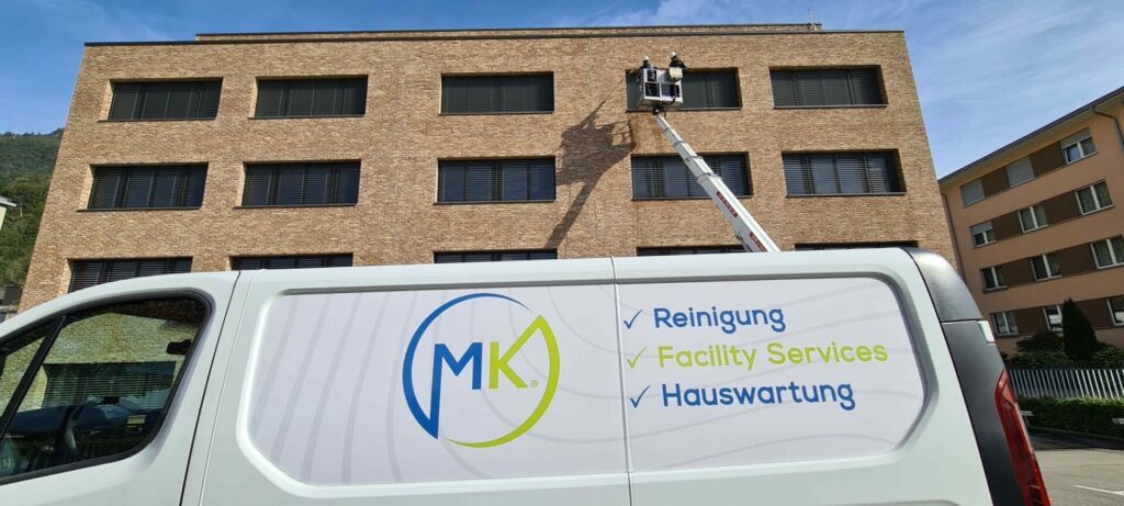 MK Mitarbeiter bei Fassadenreinigung mit Firmenfahrzeug